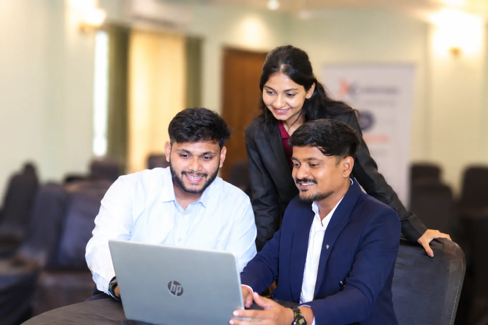 Three Xcelerate Advisory members collaborating around an HP laptop